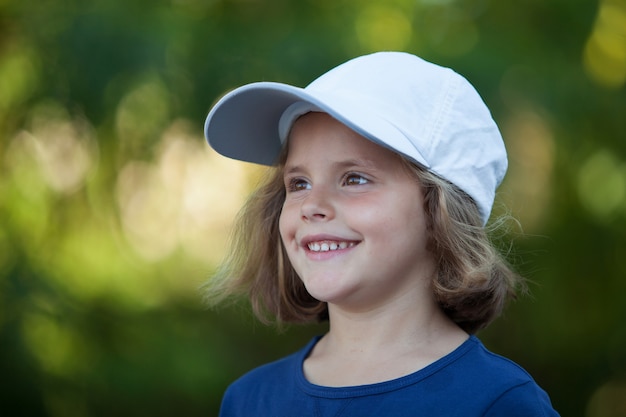 Menina bonita com um boné no parque