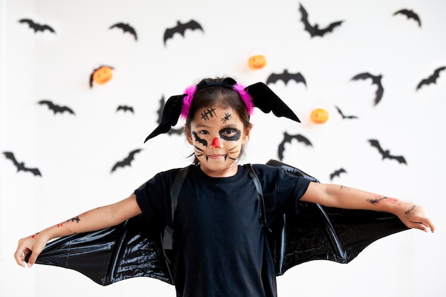 Menina bonita criança asiática vestindo maquiagem e trajes de halloween se divertindo na celebração do Dia das Bruxas