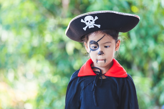 Menina bonita criança asiática vestindo maquiagem e trajes de halloween se divertindo na celebração do Dia das Bruxas