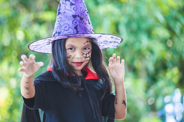 Menina bonita criança asiática vestindo maquiagem e trajes de halloween se divertindo na celebração do Dia das Bruxas