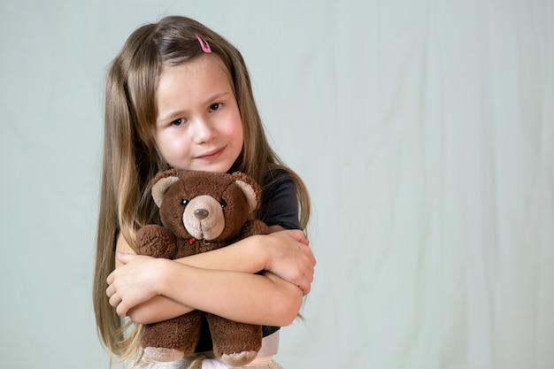 Menina bonita criança brincando com seu ursinho de pelúcia brinquedo.