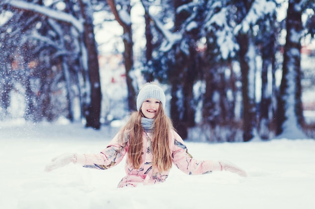 Menina bonita criança na floresta de inverno