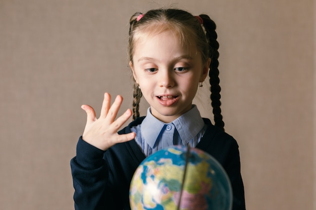 Menina bonita criança olha o globo