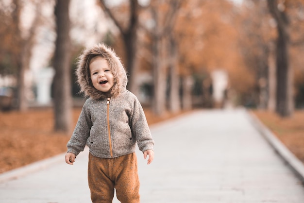 Menina bonita de 12 anos vestindo um pano casual e estiloso caminhando no parque de outono com folhas caídas ao ar livre Infância