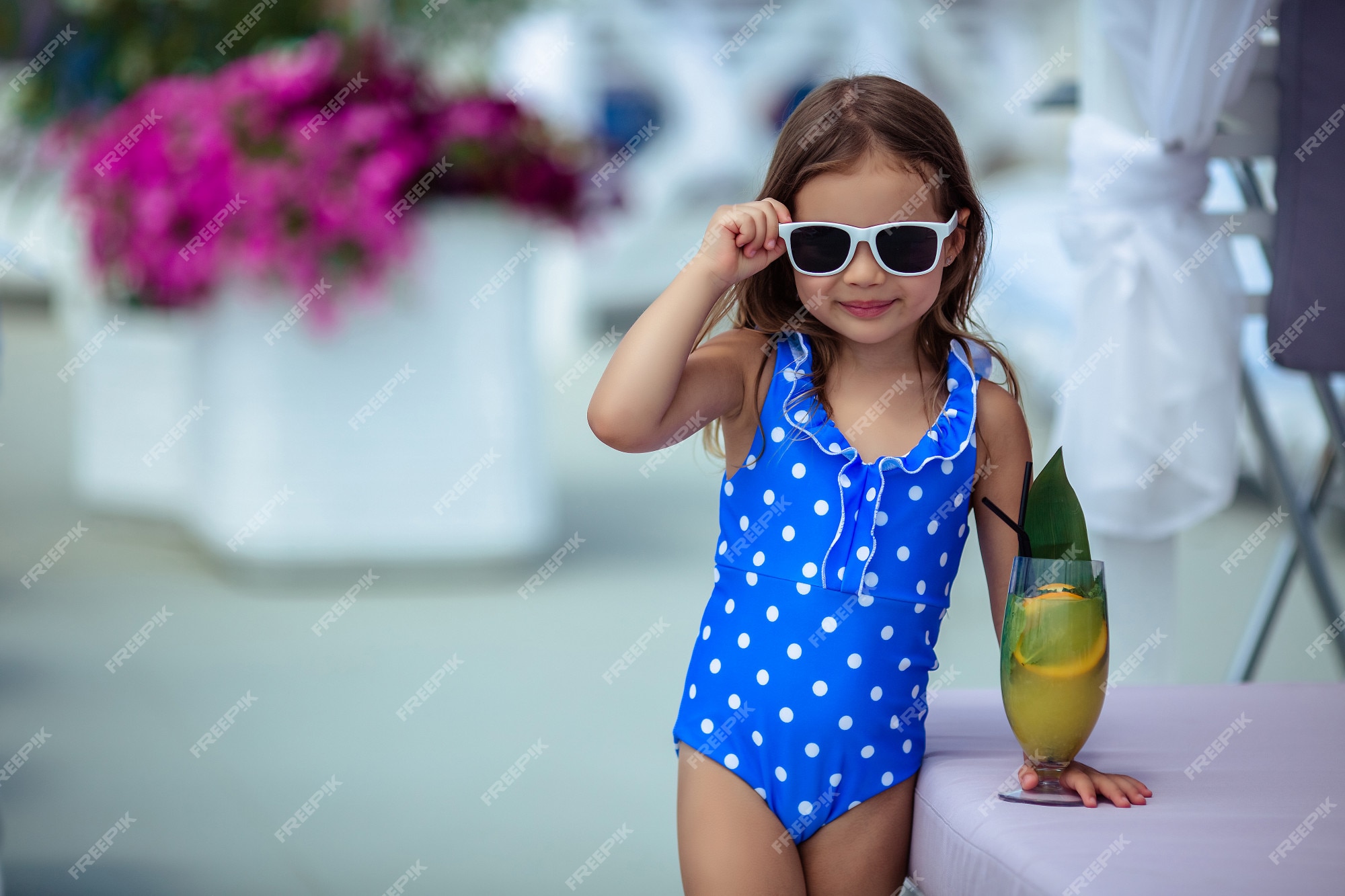 Menina bonita de 5 anos com cabelos escuros em um maiô azul de