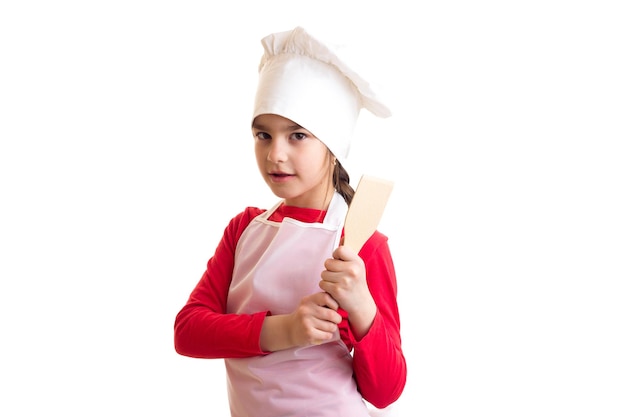 Menina bonita de camisa vermelha com avental branco e chapéu segurando o rolo no fundo branco