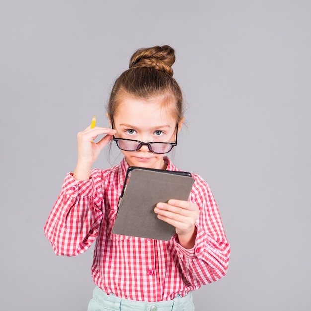 Foto menina bonita de óculos usando tablet