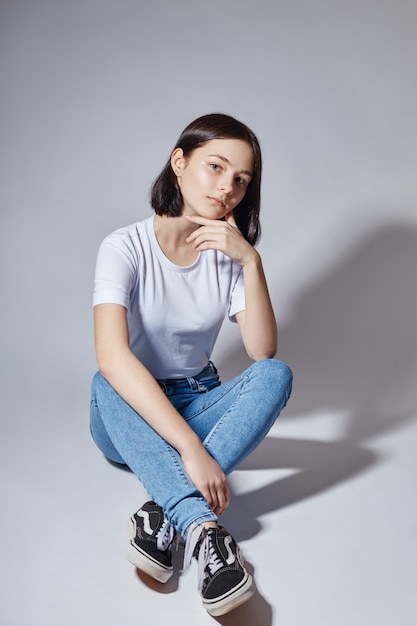 Menina bonita do modelo de moda jovem em jeans azul