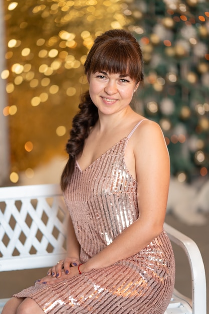 Menina bonita e elegante entre brilhos e gerlands em uma festa de Natal