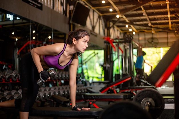 Menina bonita e esportiva fazendo exercícios na academia