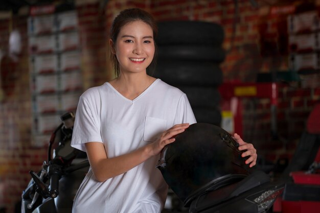 Menina bonita e um capacete de moto com motocicleta