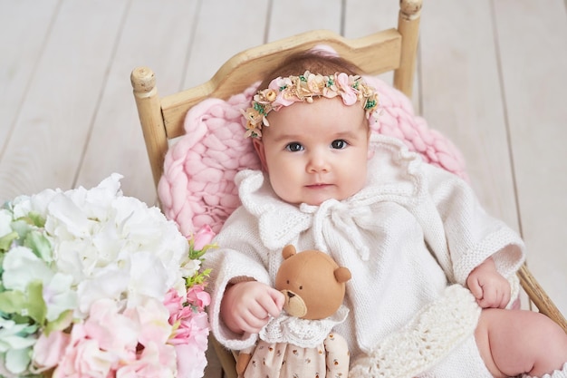 Foto menina bonita em roupas de malha e coroa de flores dia da proteção das crianças dia das mães