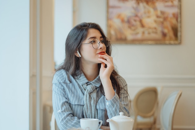 Menina bonita em um café a beber chá