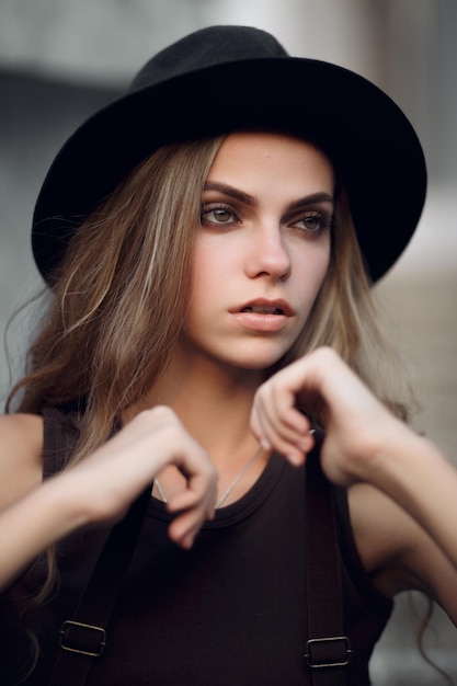 menina bonita em um top curto elegante e chapéu preto