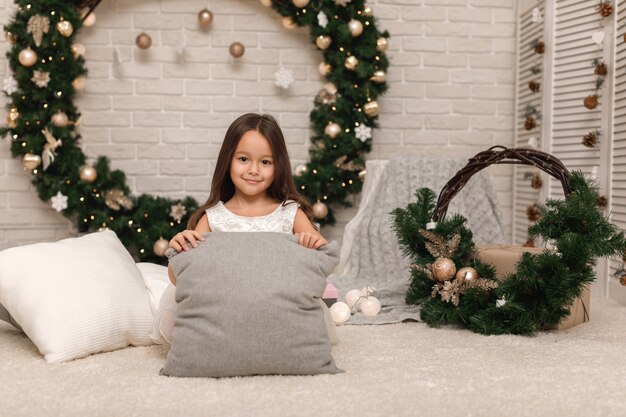 Menina bonita em um vestido branco no Natal