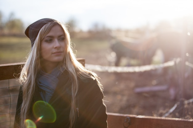 Menina bonita em uma foto estável, ao ar livre, com tonificação quente, raios de sol