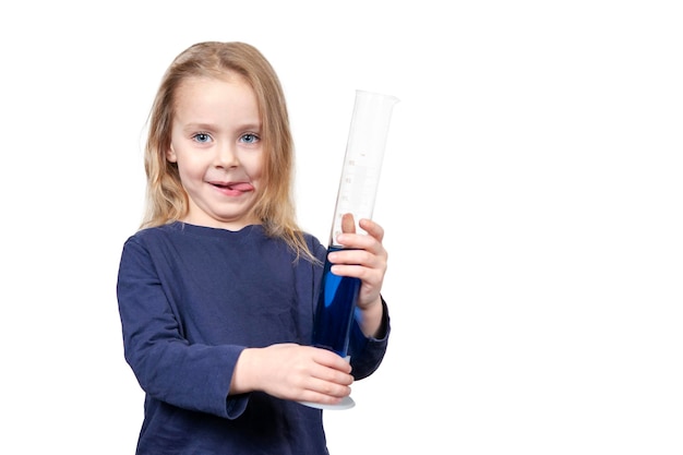 menina bonita enfiou a língua e segura um tubo de ensaio com líquido azul nas mãos, isolado no fundo branco