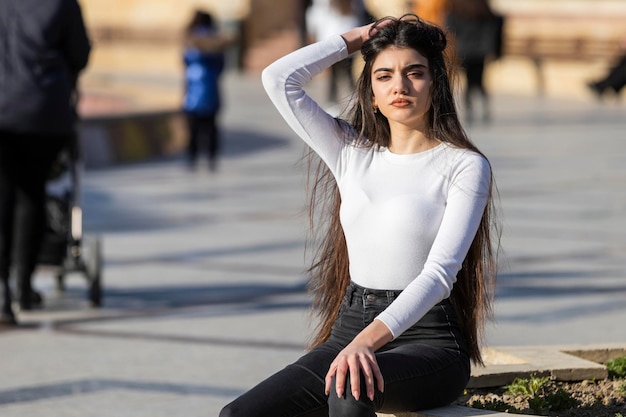 Menina bonita esticando o cabelo e olhando para a câmera Foto de alta qualidade