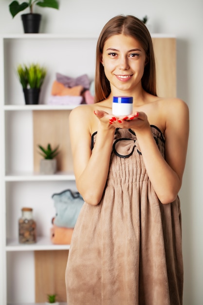 Menina bonita, fazendo o procedimento de cuidados faciais no banheiro