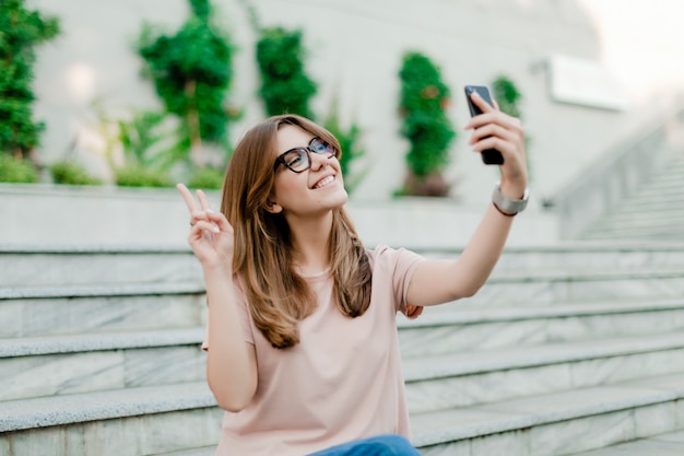 Menina bonita fazendo selfie ao ar livre