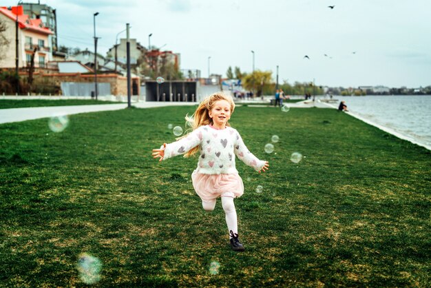 Menina bonita feliz se divertir no parque