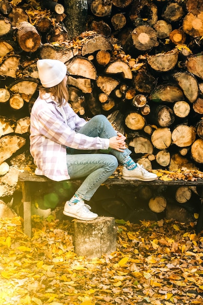 Menina bonita Hipster na bela floresta amarela de outono no fundo de madeira de madeira