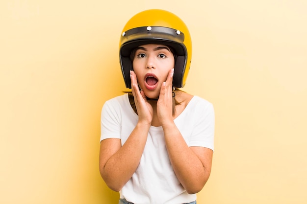 Menina bonita hispânica se sentindo chocada e assustada com o conceito de moto