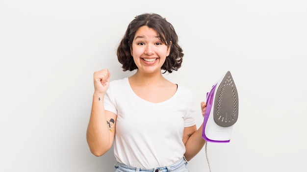 Menina bonita hispânica se sentindo chocada rindo e comemorando o conceito de lavanderia de sucesso