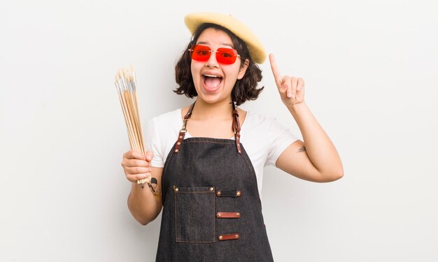 Menina bonita hispânica se sentindo um gênio feliz e animado depois de perceber um conceito de estudante de arte