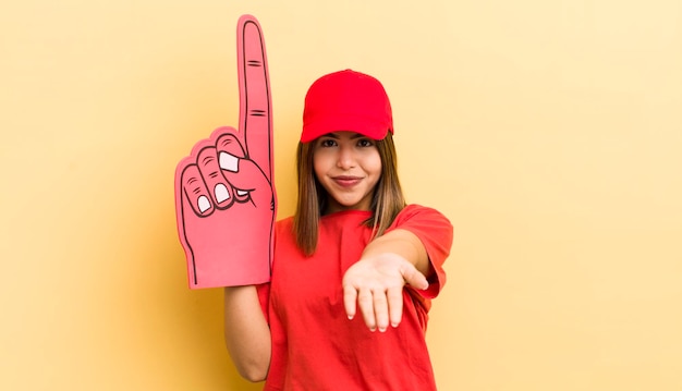 Menina bonita hispânica sorrindo alegremente com amigável e oferecendo e mostrando um conceito de mão número um conceito