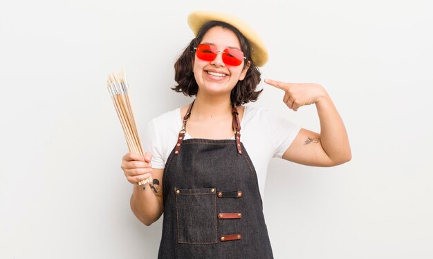 Menina bonita hispânica sorrindo com confiança apontando para o próprio conceito de estudante de arte de sorriso largo