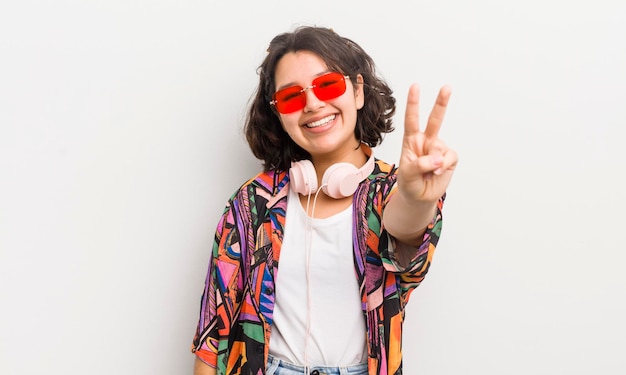 Menina bonita hispânica sorrindo e parecendo feliz gesticulando vitória ou conceito de adolescente de paz