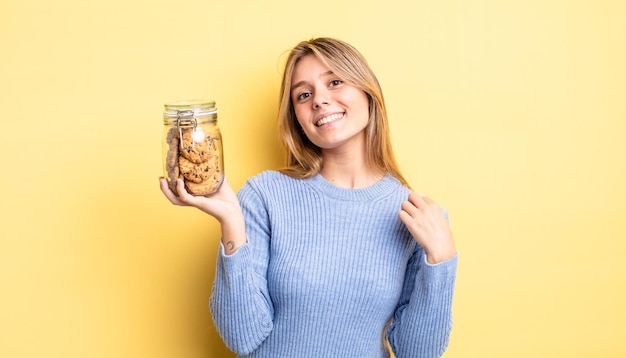 Menina bonita loira parecendo arrogante, bem-sucedida, positiva e orgulhosa. conceito de biscoitos caseiros