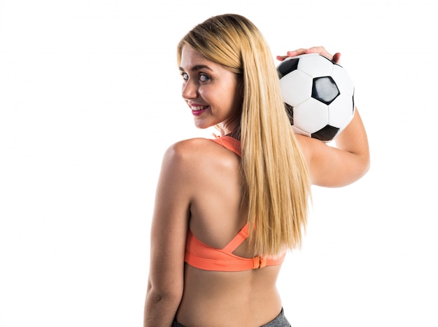 Menina bonita loira segurando uma bola de futebol