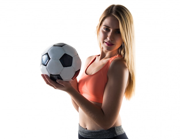 Menina bonita loira segurando uma bola de futebol