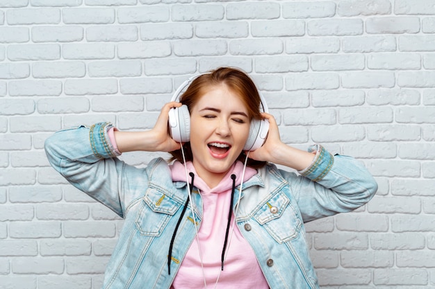 Menina bonita moda legal ouvindo música em fones de ouvido