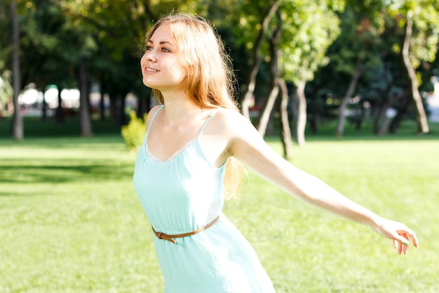 Menina bonita morena usando vestido elegante relaxando ao ar livre na grama verde e cheira a limão aromático ou limão cítrico