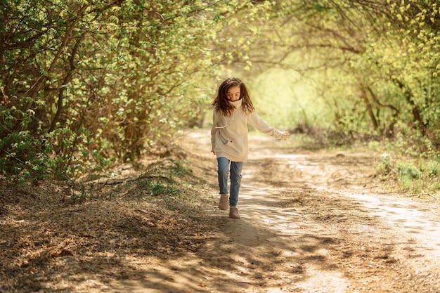 Menina bonita na caminhada no parque ensolarado da primavera Floresta de fadas