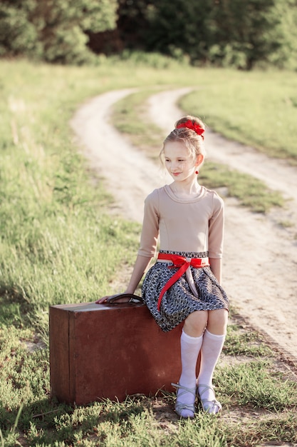 Menina bonita na mala ao ar livre