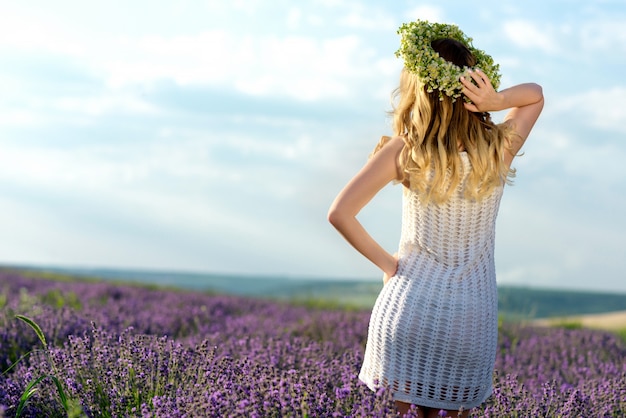 Menina bonita no campo de lavanda. mulher bonita estilo provence em vestido branco e coroa de flores