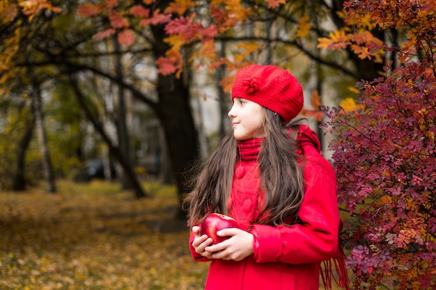 Menina bonita no parque ensolarado de outono criança brincando no parque no outono humor de outono foto de alta qualidade