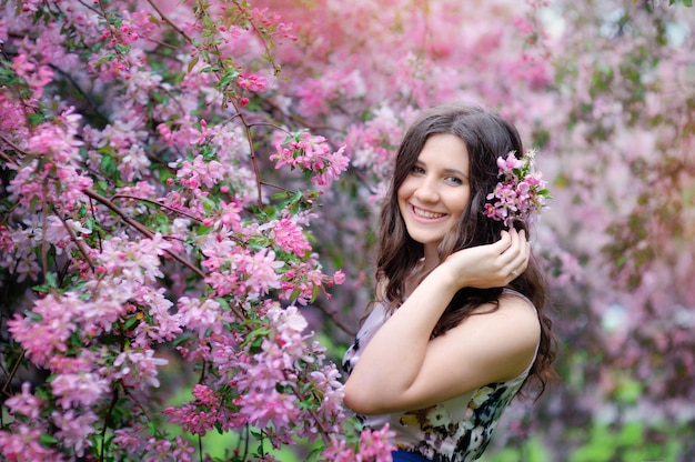 Menina bonita no parque primavera com retrato de estilo de vida de flores