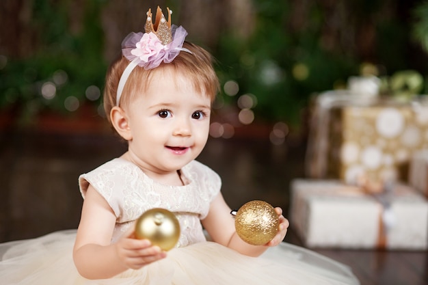 Menina bonita no vestido branco, jogando e sendo feliz com as luzes de natal