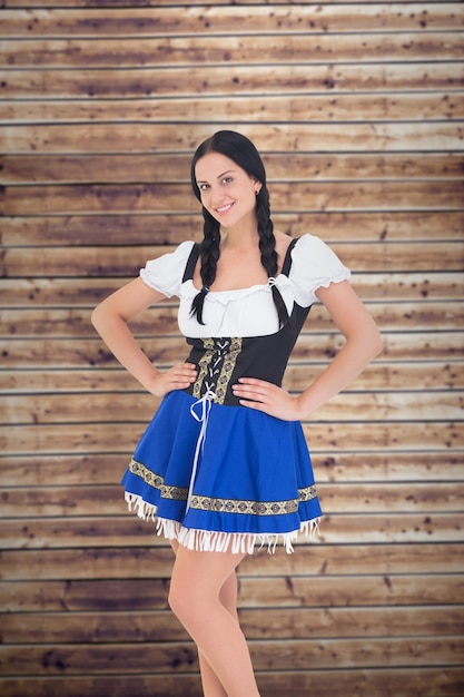 Menina bonita oktoberfest sorrindo para a câmera contra pranchas de madeira