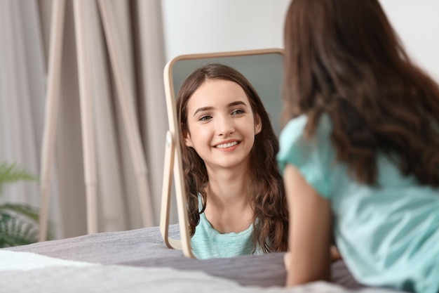 Menina bonita olhando no espelho em casa