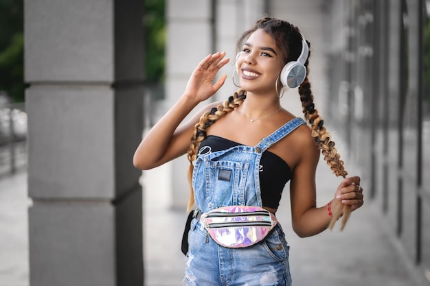 Menina bonita ouvindo música com seus fones de ouvido na rua