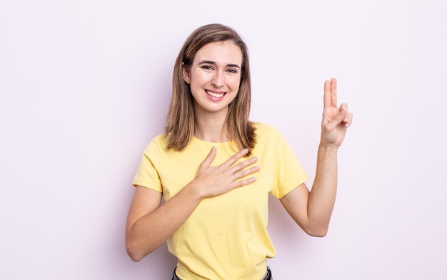 Menina bonita parecendo feliz, confiante e confiável, sorrindo e mostrando sinal de vitória, com uma atitude positiva