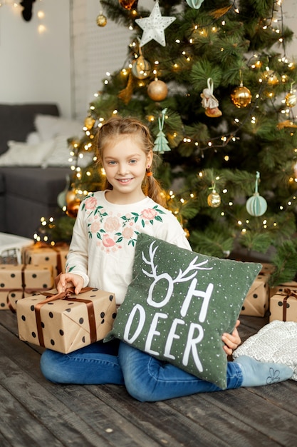 Menina bonita perto da árvore de natal