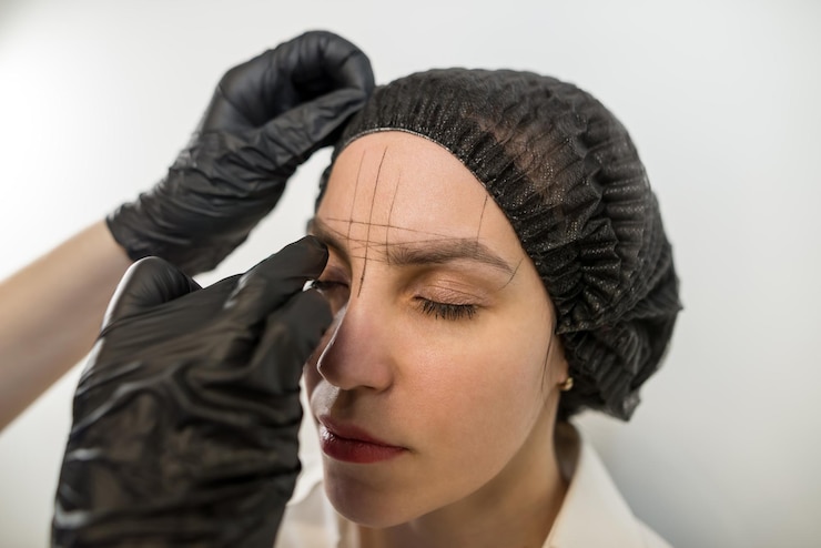 Foto menina bonita pinçando as sobrancelhas em um salão de beleza conceito de beleza cosmetologista arranca sobrancelhas do cliente por fio correção de sobrancelha enfiando maquiagem permanente microblading sobrancelha close-up