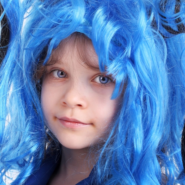 Menina bonita posando de peruca azul para o Halloween